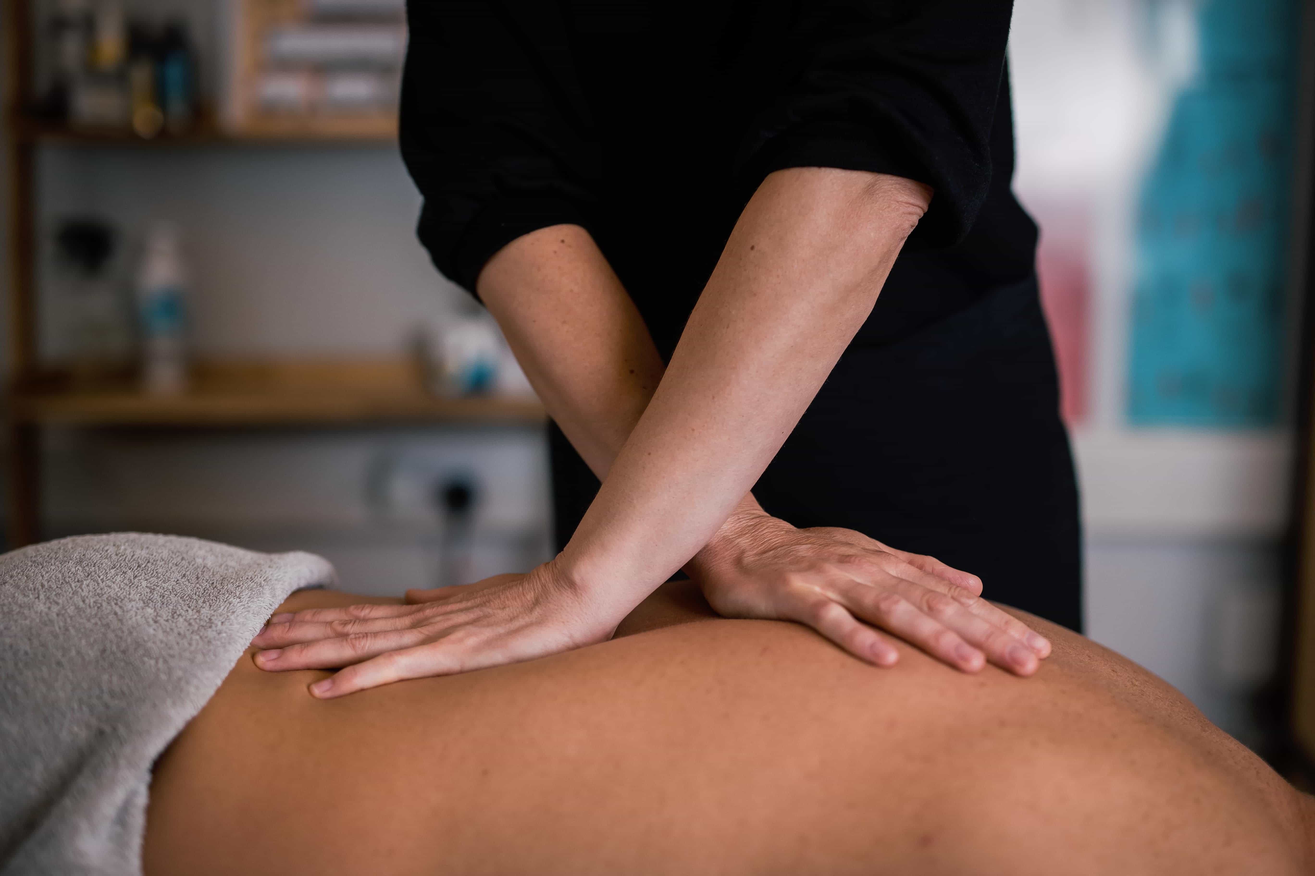 woman gently massaging a persons back